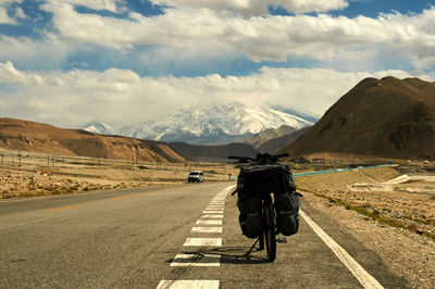 People riding motorcycle on road against mountain range