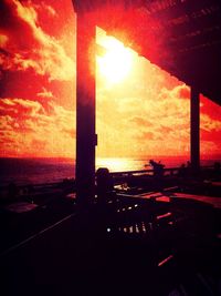 Sun shining through clouds over sea