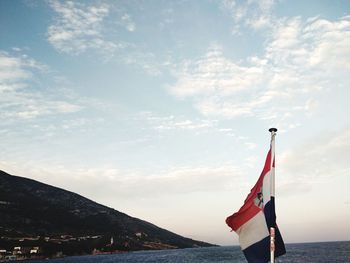 Low angle view of flag on beach against sky