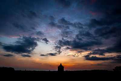 Silhouette of landscape against cloudy sky