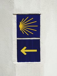 Close-up of arrow sign on wall