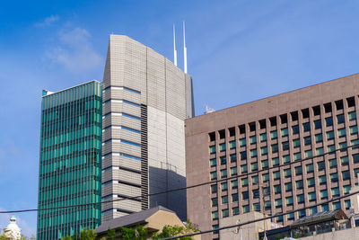 Low angle view of modern buildings against blue sky