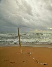 Scenic view of beach against cloudy sky