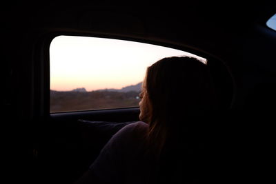 Close-up of woman looking through car window