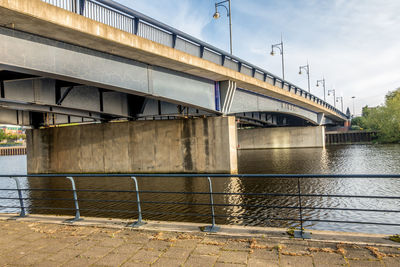 Bridge over river in city against sky