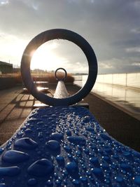 Close-up of water wheel against sky during sunset