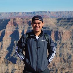 Portrait of smiling young man standing on rock