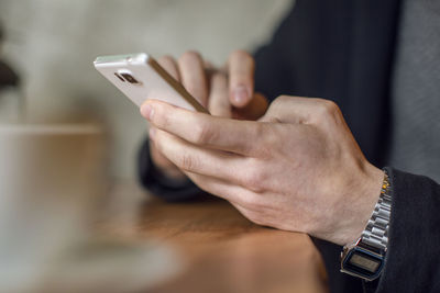 Midsection of man using mobile phone