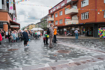 People on street in city against sky