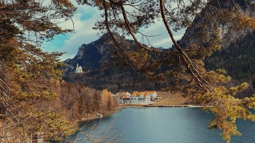 Scenic view of lake against cloudy sky with neuschwanstein castle