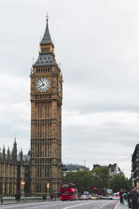 London, the big ben tower of the famous palace of westminster with urban traffic and tourists