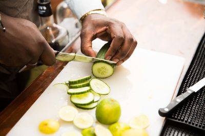 Man cutting cucumber in kitchen