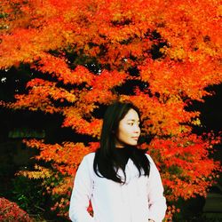 Beautiful young woman standing in park during autumn