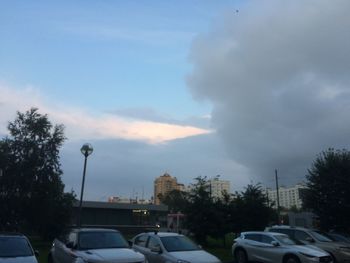 Cars on street in city against sky