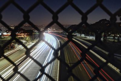 Light trails on chainlink fence at night