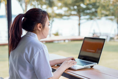 Side view of woman using mobile phone