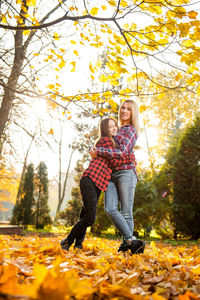 Full length of a happy woman with autumn leaves