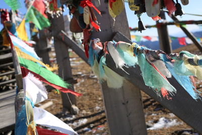 Close-up of multi colored flags hanging on metal fence