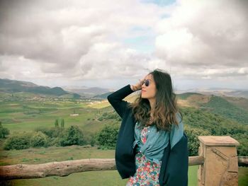 Portrait of woman standing against mountain landscape 