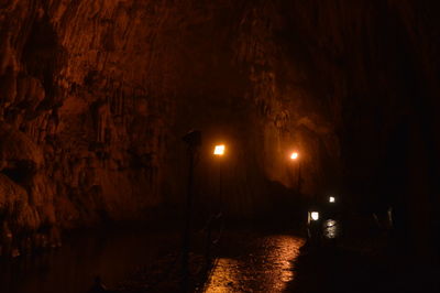 Illuminated cave in water at night