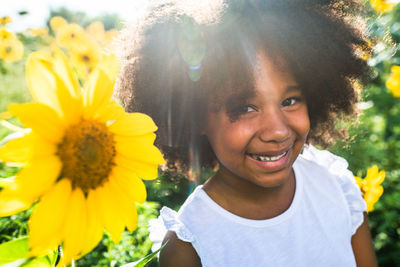 Portrait of smiling girl with yellow flower