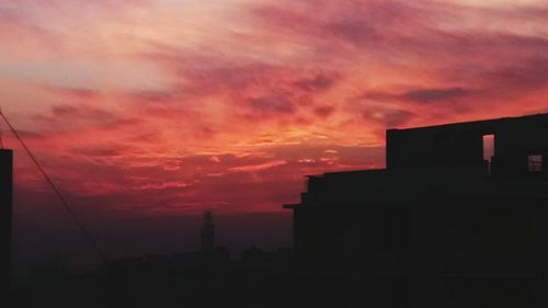 Silhouette of building against dramatic sky during sunset
