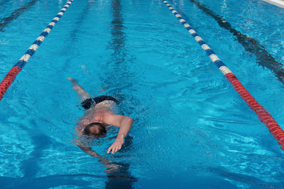 Middle age man swimming in open air pool. active lifestyle and leisure. sporty man enjoing swimming. 