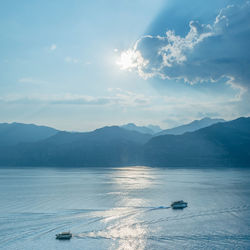 View of sea by mountains against sky