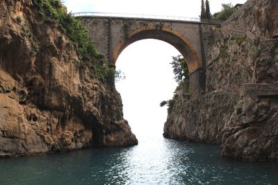 Arch bridge over sea against clear sky