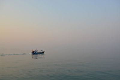 Boat sailing in sea against sky