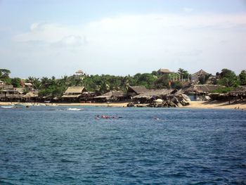 Scenic view of sea and buildings against sky