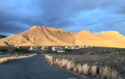 Road leading towards mountain against sky