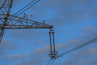 Low angle view of electricity pylon against sky