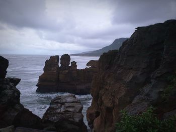 Rock formations by sea against sky