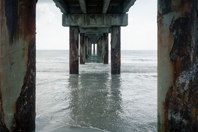 Pier with rusty columns over sea