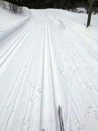 High angle view of tire tracks on snow covered land