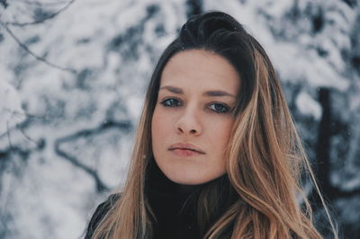 Portrait of woman standing against trees during winter