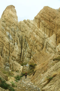 Woman walking on land by rock formation