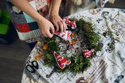 Girl florist decorator making a christmas holiday wreath