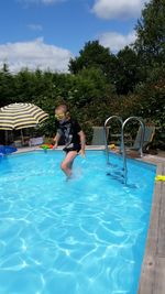 Rear view of woman swimming in pool