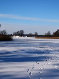 Snow covered field against sky