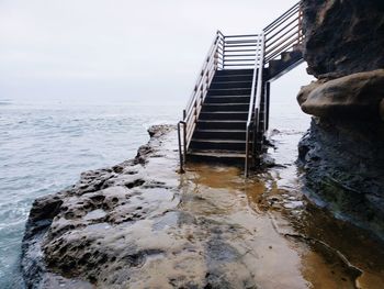 Staircase by sea against sky