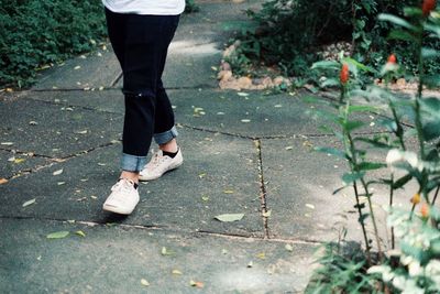 Low section of woman standing on footpath