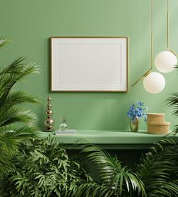 Mock up poster frame on the green shelf with beautiful plants.3d rendering