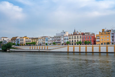 Bridge over river in city against sky