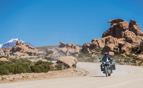 Man riding touring motorcycle on dusty road in bolivia