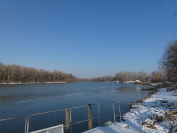 Scenic view of lake against clear sky during winter