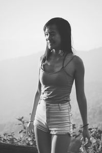 Happy woman standing on land against sky