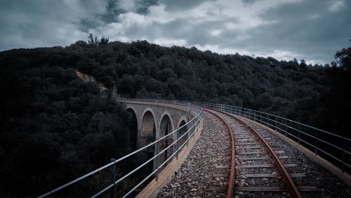 Railroad tracks by trees against sky