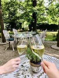 Midsection of person holding beer glass on table